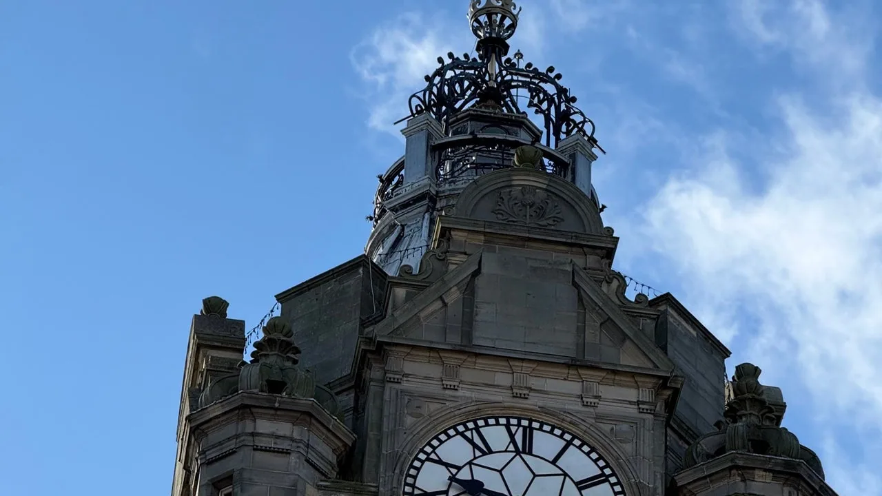 Ornate clock tower detail against a blue Edinburgh sky