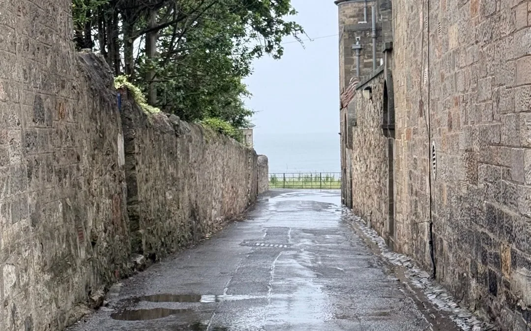Historic stone lane leading towards the sea in St Andrews